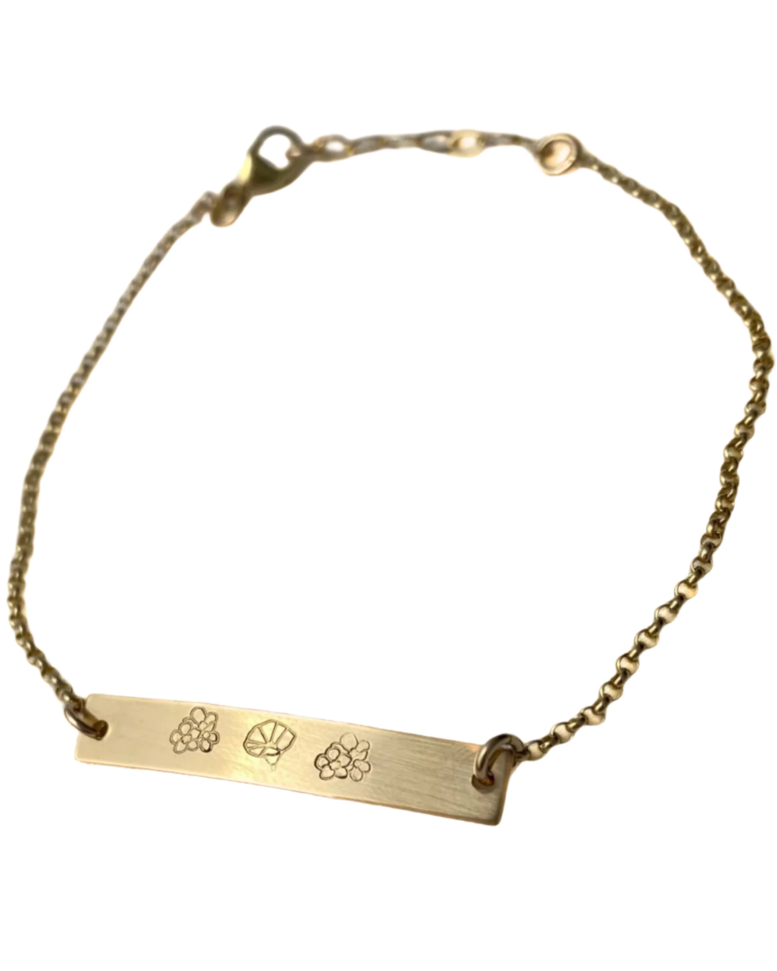 Gold bracelet with engraved symbols on a white background