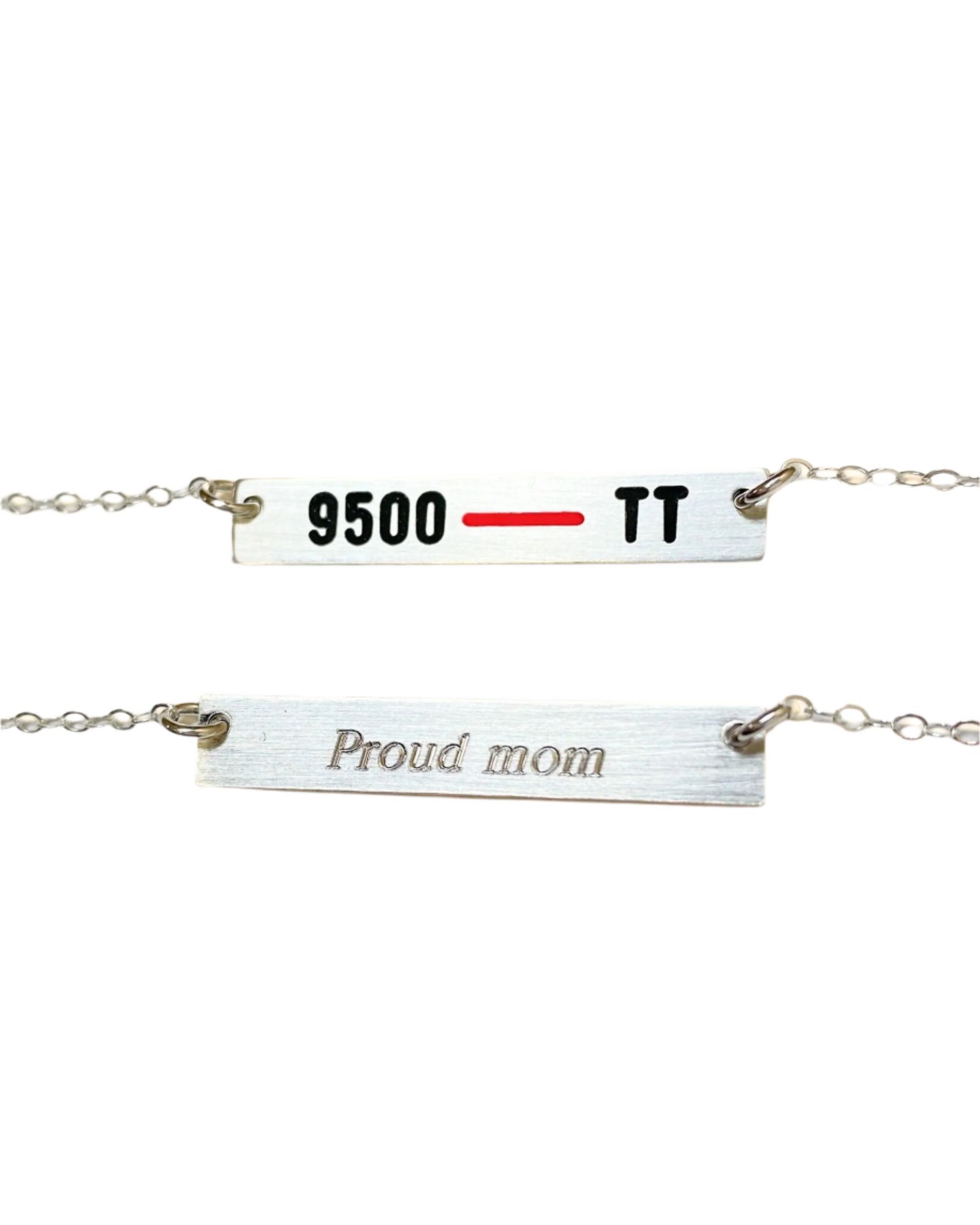 A necklace with two horizontal bars, the top bar is engraved with '9500 - TT' and the bottom bar reads 'Proud mom'. The bars are silver with a red line across the top bar.